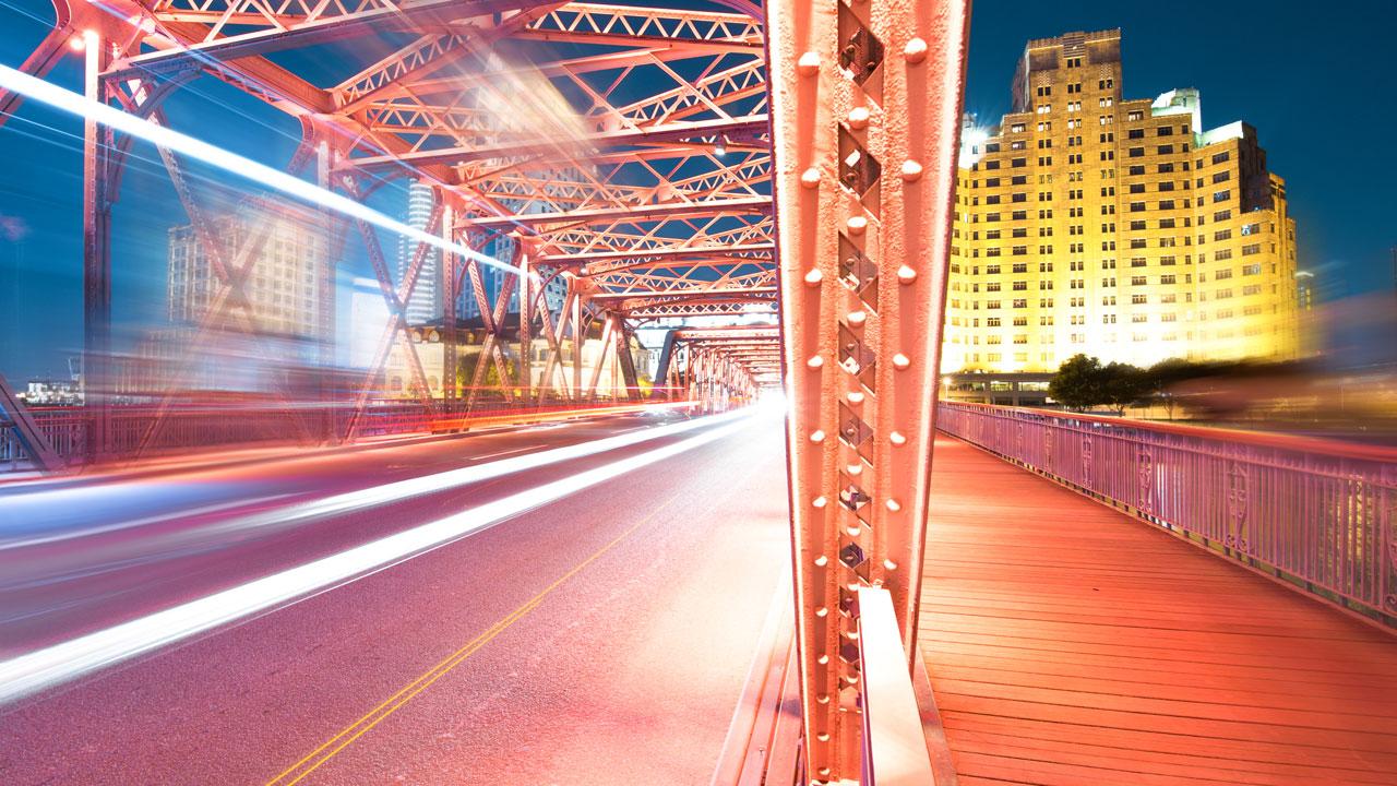 A pink hued nighttime street scene with blurred motion and lights