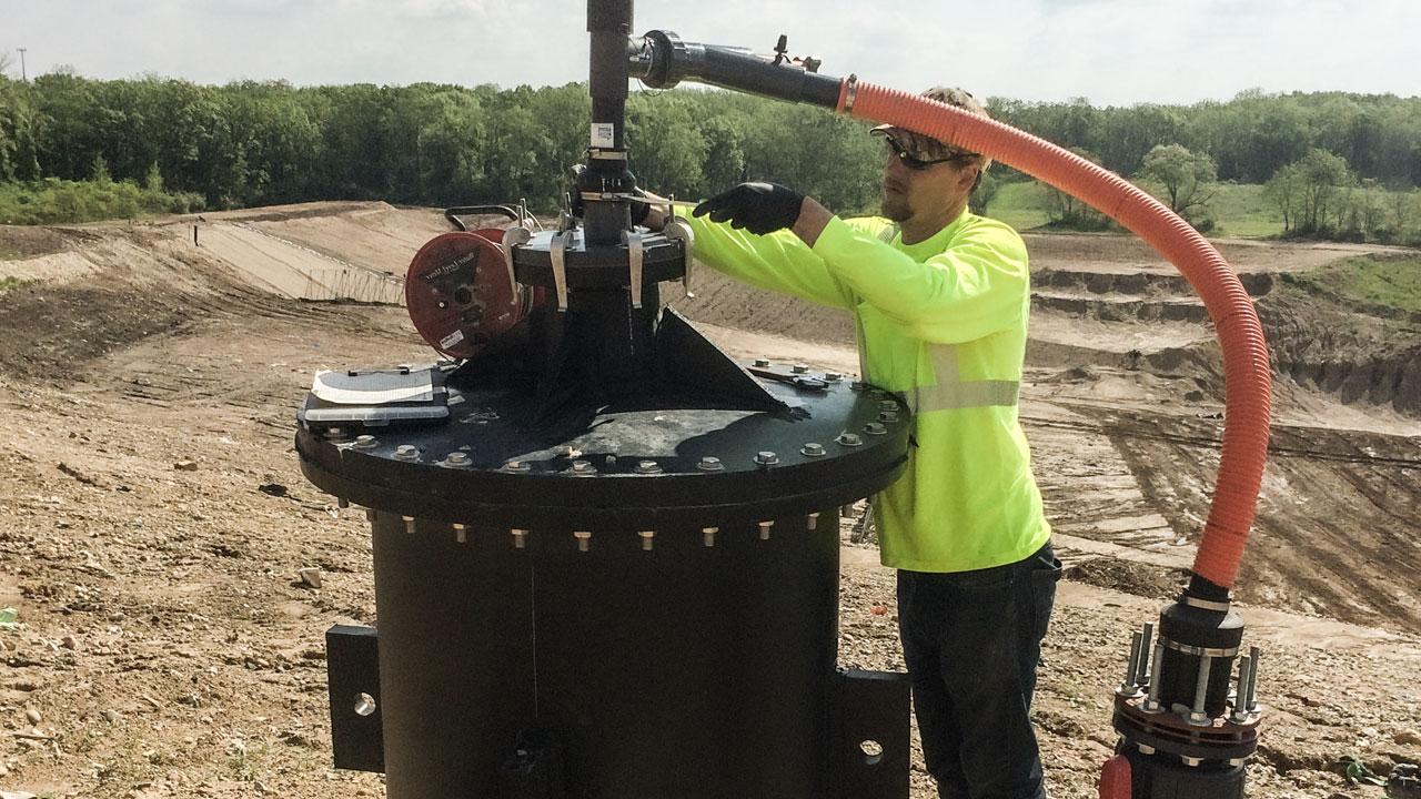 Technician performing maintenance on a landfill gas well